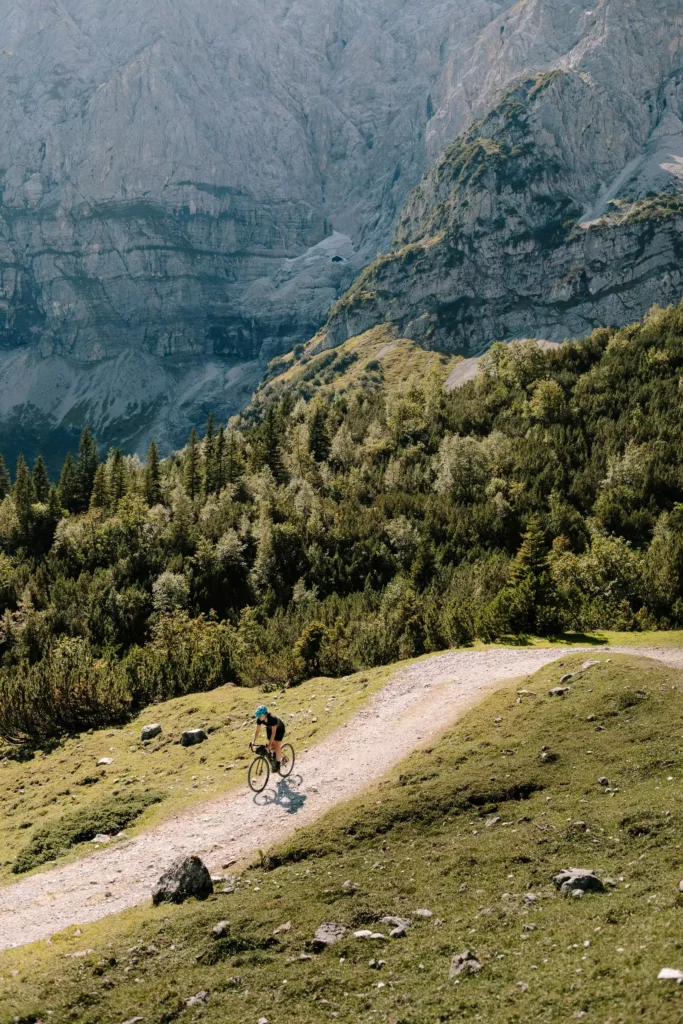 Mountain biker on a forest path before a rock formation in the Black Forest countryside near Maison Talmühle Resort Spa
