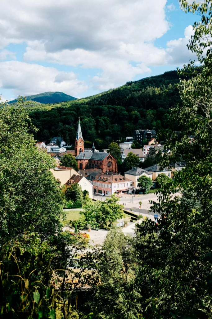 View of Sasbachwalden in the Black Forest, with its church, houses and wooded hills, on a day trip from the Maison boutique resort